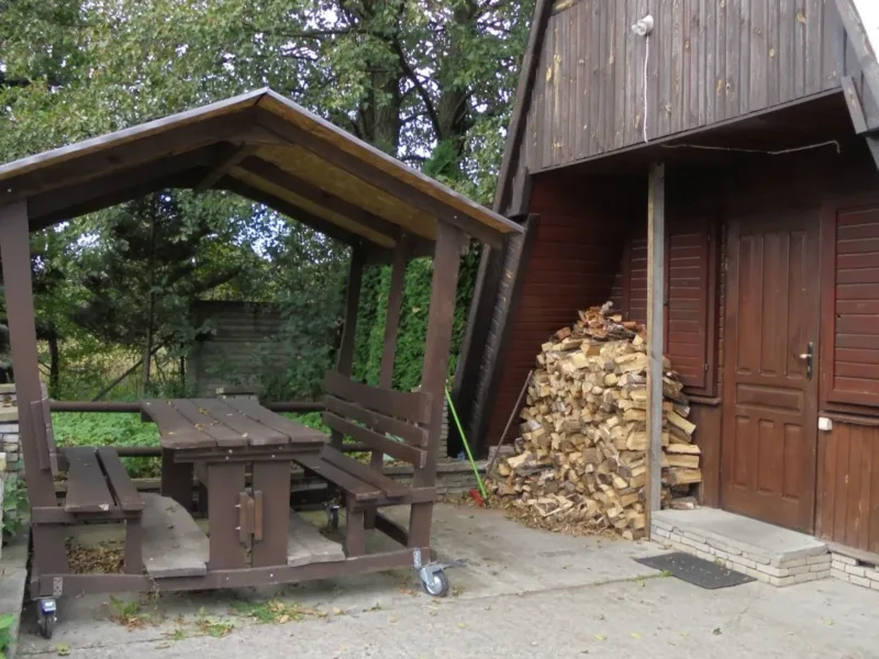 Altana ze stołem i drewno na opał przy domku typu Brda