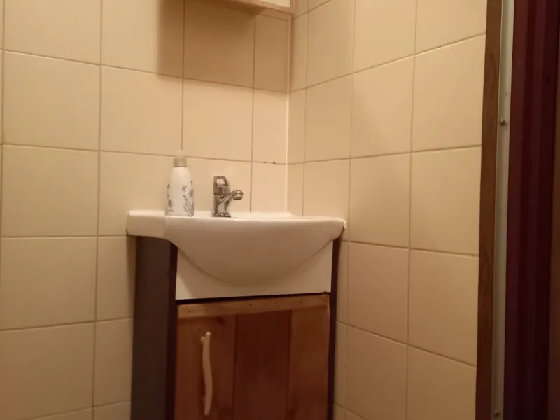 Umywalka z szafką i lustrem w łazience domku nr 1