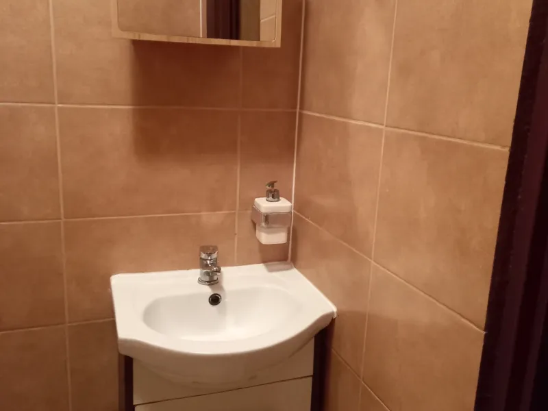 Umywalka z szafką i lustrem w łazience domku nr 2