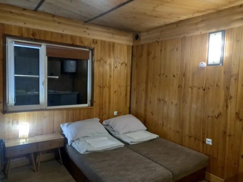 Pokój w domku nr 2 z dwoma łóżkami i drewnianą boazerią