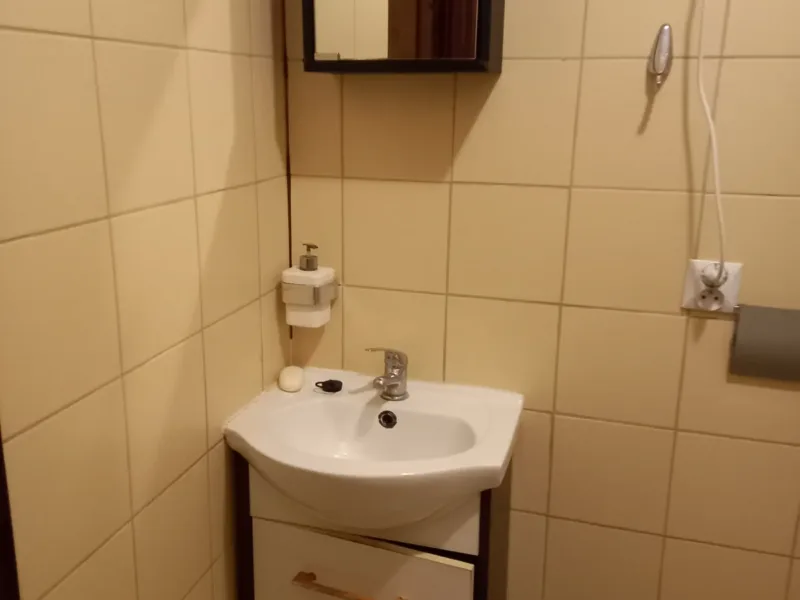 Łazienka w domku nr 4 z umywalką i lustrem