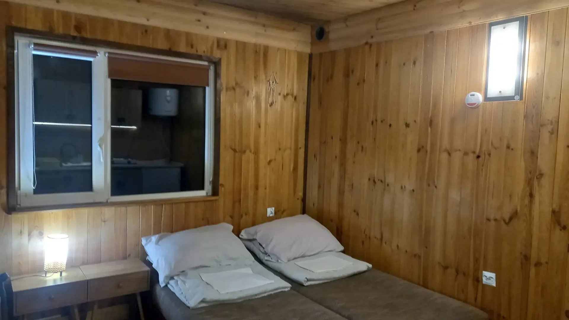 Pokój w domku nr 2 z dwoma łóżkami i drewnianą boazerią