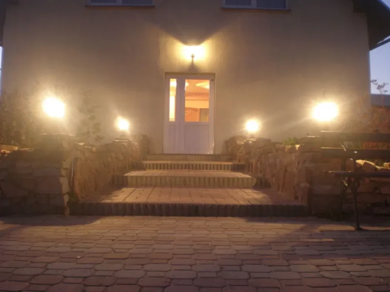Wejście do mini pensjonatu wieczorem, oświetlone schody